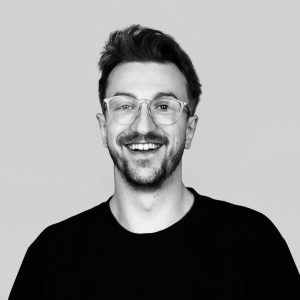Portait, junger Mann mit Brille und Bart.